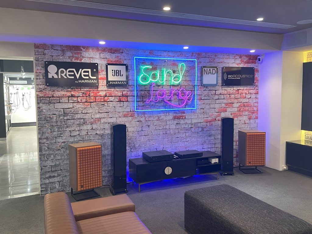 Retail setting themed as lounge room with sound system and branding.